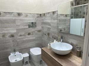 Un baño con un lavabo blanco y un inodoro. en SIKELIA LUXURY ROOMS, en Agrigento