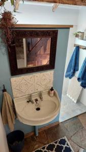 a bathroom with a sink and a mirror at Lacebark Cottage in Hilton