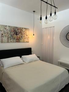 una camera da letto con un letto con lenzuola e luci bianche di Ortigia Loft Via Malta, 22 a Siracusa