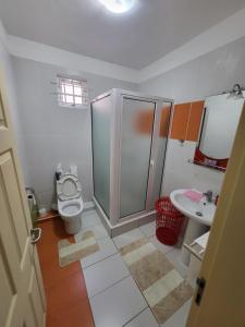 a bathroom with a shower and a toilet and a sink at Cocon des iles in Flic-en-Flac +4 photos