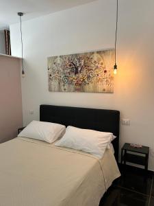 sypialnia z łóżkiem z obrazem na ścianie w obiekcie Ortigia Loft Via Malta, 22 w Syrakuzach