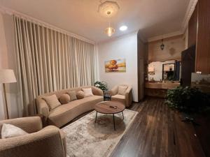 a living room with a couch and a table at Ban Luxury Apartments in Al Khobar
