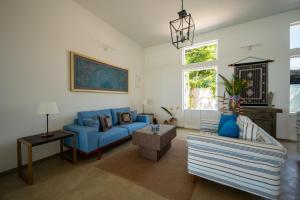 un soggiorno con divani blu e una finestra di Nil Ralla a Talpe