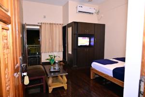 um quarto de hotel com uma cama e uma mesa em Jaya Paradise em Māvalli