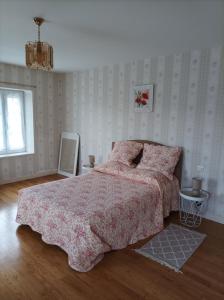 - une chambre avec un lit et une couette rose dans l'établissement Le logis de LANGE apt Les Aigrettes, à Saint-Hilaire-la-Palud
