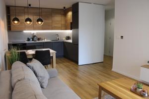 ein Wohnzimmer und eine Küche mit einer Couch und einem Tisch in der Unterkunft Apartmán Limba in Starý Smokovec