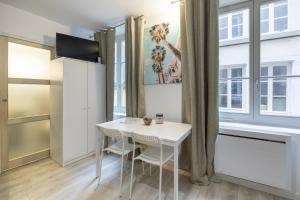 a small white table and chairs in a room with a window at Le petit MIAMI in Thionville