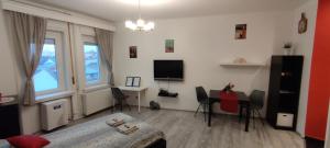 ein Wohnzimmer mit einem Tisch und einem TV in der Unterkunft Mester24 Apartman in Budapest