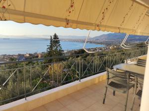 balcón con mesa, sillas y vistas al agua en Galini Apartments, en Kalamata