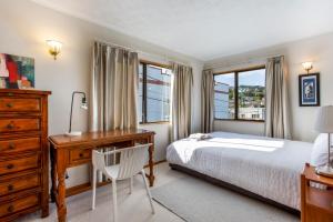 um quarto com uma cama, uma secretária e janelas em Prime Location! 4BR Sunny Character Home near CBD Auckland em Auckland