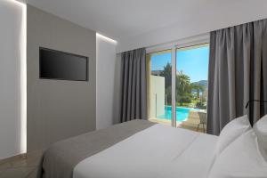 a bedroom with a bed and a view of a pool at Lindos Royal Resort in Líndos