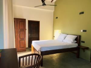 um quarto com uma cama e uma porta de madeira em Tsuru Villa em Udawalawe