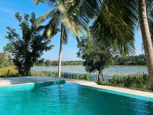 a swimming pool with a view of the water at Tsuru Villa in Udawalawe
