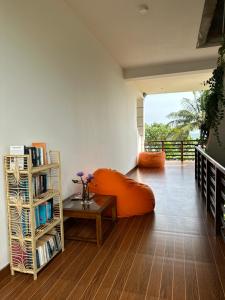 a living room with an orange couch and a book shelf at MIRISSA Reef Serenity in Mirissa