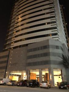 ein großes Gebäude mit davor geparkt in der Unterkunft Sway Suites in Manama