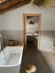 a bathroom with a tub and a bedroom with a bed at Finca Las Botas in Almansa