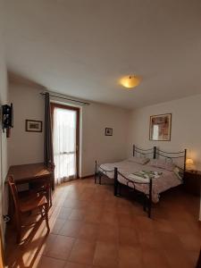 1 dormitorio con cama, escritorio y ventana en B&B La Verbena, en Siena
