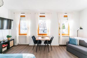 een woonkamer met een tafel en stoelen en een bank bij Deluxe Studio, PS4, Parken, Netflix, Klinikum in Bendorf