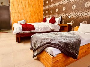 a hotel room with two beds in a room at Hotel Kanchan Classic Manali in Manāli