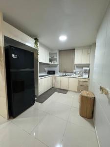 a kitchen with a black refrigerator and a trash can at Homestay Cyberjaya AC Home 4R3B Free Wifi Netflix in Cyberjaya