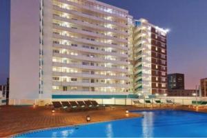 a large building with a swimming pool in front of a building at Sea view tranquility Durban in Durban