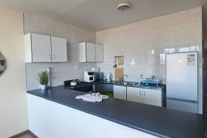 a kitchen with a black counter top and a refrigerator at Sea view tranquility Durban in Durban