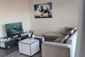 a living room with a couch and a cow on the wall at Sea view tranquility Durban in Durban