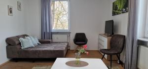 - un salon avec un canapé et deux chaises dans l'établissement Bahnhof City Loft & Apartments, à Augsbourg