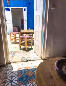 uma porta aberta para um quarto com uma mesa e cadeiras em Dar merouan em Essaouira