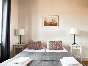 a bedroom with a bed with two lamps on it at Stay Inn Apartment Sveavägen in Stockholm