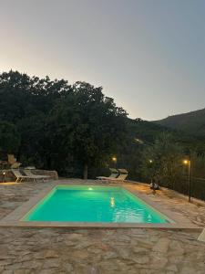 een groot zwembad in een tuin met een berg bij Agriturismo Campo dei Lupi in Vicopisano