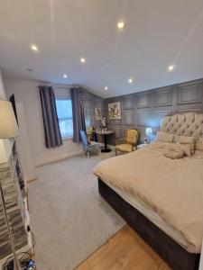 una grande camera da letto con un grande letto e una scrivania di Cosy Studio Apartment In FULHAM a Londra
