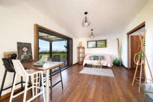 Habitación con cama, mesa y sillas. en Maena - Magnifique Villa de 8 personnes avec piscine et vue mer proche du lagon de Saint-Leu en Saint-Leu