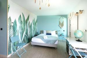 1 dormitorio con 1 cama con pared azul en Maena - Magnifique Villa de 8 personnes avec piscine et vue mer proche du lagon de Saint-Leu en Saint-Leu
