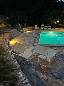 - deux chaises longues et une piscine la nuit dans l'établissement Agriturismo Campo dei Lupi, à Vicopisano