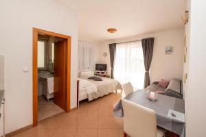 Apartmani Trogir في تروغير: غرفة معيشة مع سرير وطاولة في غرفة