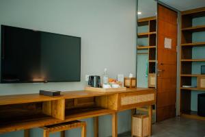 a living room with a television on a wooden table at Ecozy Dijiwa Canggu in Canggu