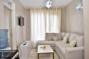 - un salon blanc avec un canapé et une table dans l'établissement Meshivon suite, à Nairobi