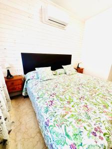 1 dormitorio con 1 cama grande y edredón de flores en Hostal La Taberna, en Arenas de San Pedro