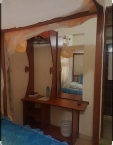 a bedroom with a wooden table with a mirror at THE DESERT ROSE HOTEL VOI in Voi