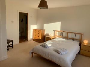 a bedroom with a bed with two towels on it at Stroma, Dunnet, spacious holiday house with sauna. in Brough
