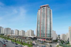 a large tall building in a city with traffic at Radisson Residences Avrupa TEM Istanbul in Istanbul