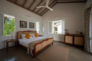 a bedroom with a bed and two windows at Nil Ralla in Talpe