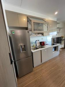 a kitchen with a stainless steel refrigerator and white cabinets at Vinhomes West Point Studio W1-2510 in Hanoi