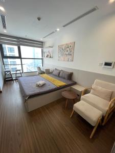 a bedroom with a bed and a couch and chairs at Vinhomes West Point Studio W1-2510 in Hanoi