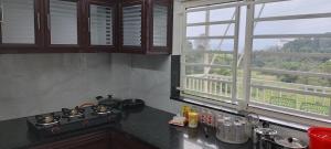 a kitchen with a stove and a window at Casa valley peruim villa in Anachal