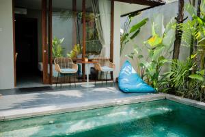 a patio with a table and chairs next to a pool at Ecozy Dijiwa Canggu in Canggu