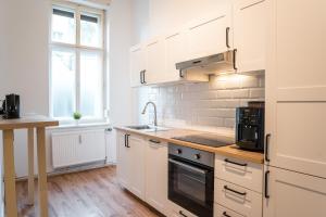 柏林的住宿－2 Bedroom Apartment in convinient location，厨房配有白色橱柜和水槽