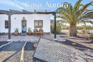 a house in the middle of a yard with palm trees at Casa Pilar, Aurora y Tarabilla en Finca Ecológica in Teguitar