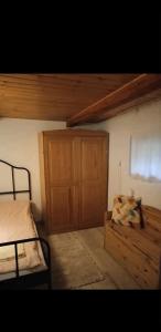 een slaapkamer met een bed en een houten kast bij Chata w górach in Porąbka